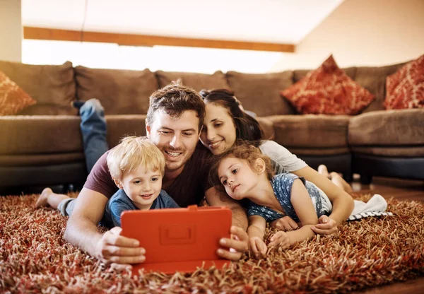 Τεχνολογία Τους Διασκεδάζει Όλους Μια Ευτυχισμένη Νεαρή Οικογένεια Κοιτάζοντας Ένα — Φωτογραφία Αρχείου