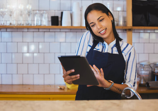 Female cafe or small business manager on phone call, reading a digital tablet in her store. Startup business woman, entrepreneur or employee working in a coffee shop preparing online grocery sales.