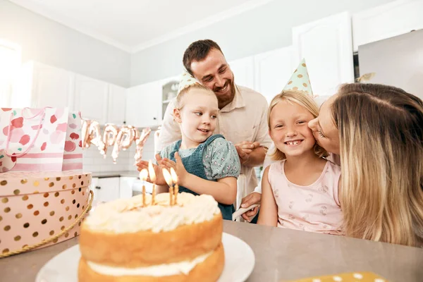 Family birthday party, smile in home kitchen, happy mother kiss girl child, children love fun quality time together and bond over bake cake and food. Kid look at the camera of happiness in house