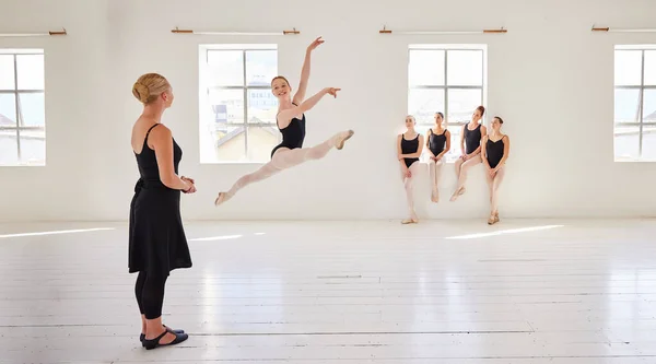 Ballet teacher, dance students and studio with group diversity of ballerina dancers in creative theatre jump performance. Theater room, art or training women in beauty or elegant learning stage class.