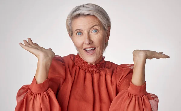 Wow and surprise senior woman with emoji hand gesture or expression on studio grey background. Senior fashion business lady with hands for shocking unbelievable pension deal, discount or sale.