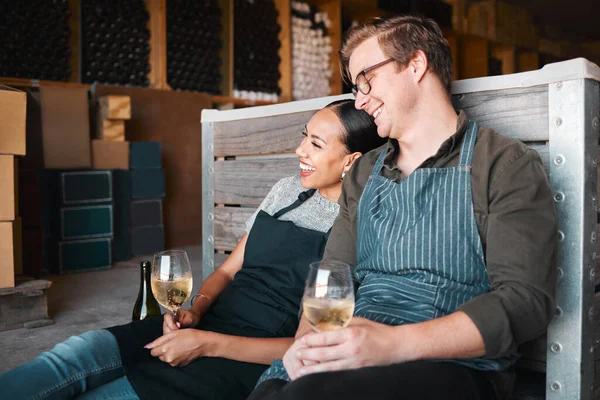 Laughing friends, wine tasting and couple with happy smile bonding on countryside farm with drink glass. Interracial man, woman or industry worker people in environment vineyard restaurant distillery.