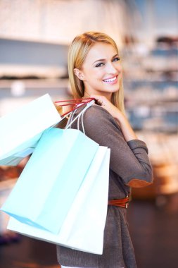 Portrait of a mall shopping, woman customer and retail discount sale at a fashion boutique. Beautiful female with a smile and shopping bags happy about store stock content spending money and cash.