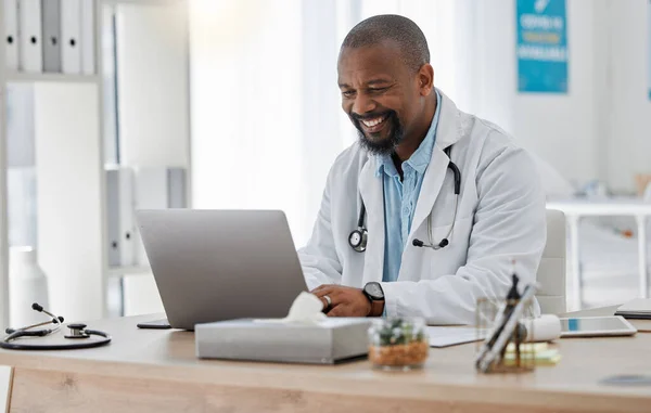 Doctor, medical and healthcare worker on laptop checking history or medical data at hospital or clinic working with tech. GP man on computer reading emails, patient records and documents.