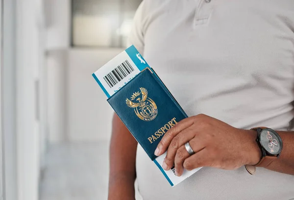 Man at airport with passport, travel visa and ticket for plane flight of international immigration. Hands of tourist, traveller and passenger waiting for airplane departure with identity documents.