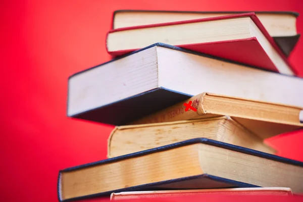 Books, education and learning for school or academic research isolated on a red studio background. Studying, reading and a library book for scholarship research to gain knowledge.