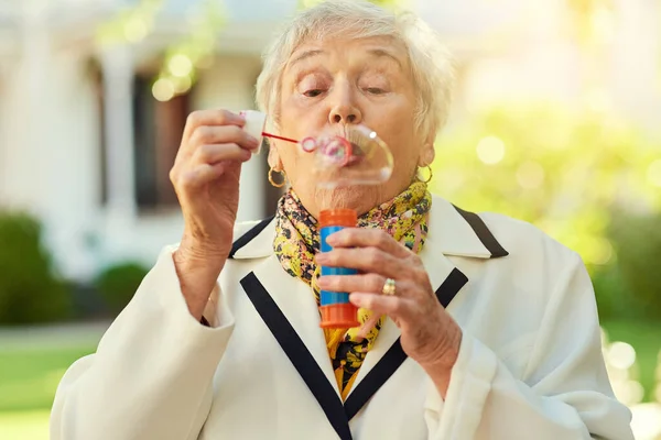 Youre Only Old You Feel Fun Loving Senior Woman Blowing — Foto Stock