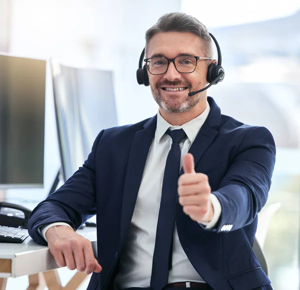 Thumbs up, yes and success deal for a call center agent with contact us and happy about telemarketing. Portrait of a CRM manager or customer service employee smiling due to good business.