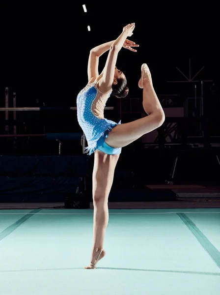 Sports competition woman dancer dancing in a dark ballet arena or training performance for a concert, theatre production or professional event. Young person, athlete or artist in gymnastics dance.