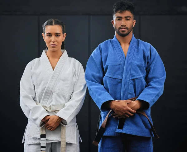 .Fitness, motivation and discipline karate training with a student and teacher standing proud in a center or dojo. Young woman learning defense, strength and endurance lesson from martial arts coach