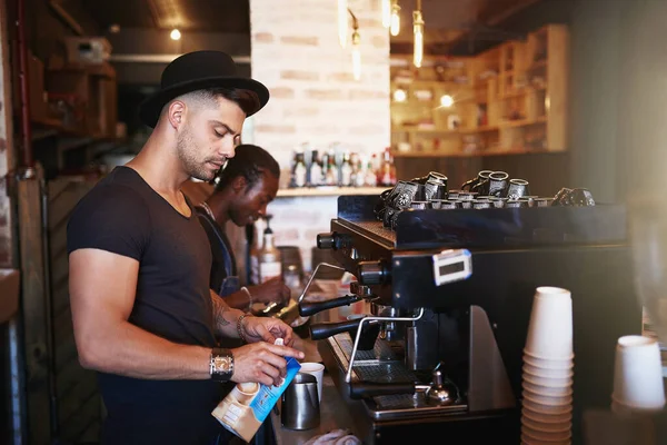 Not just a coffee shop, its a coffee experience. a young man operating a coffee machine in a cafe