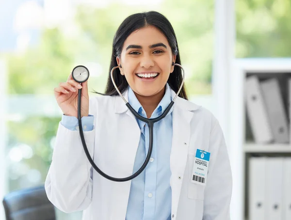 Healthcare, medicine and a happy doctor, woman in her office with a smile and a stethoscope. Vision, success and empowerment, portrait of a female medical professional or health care employee at work.