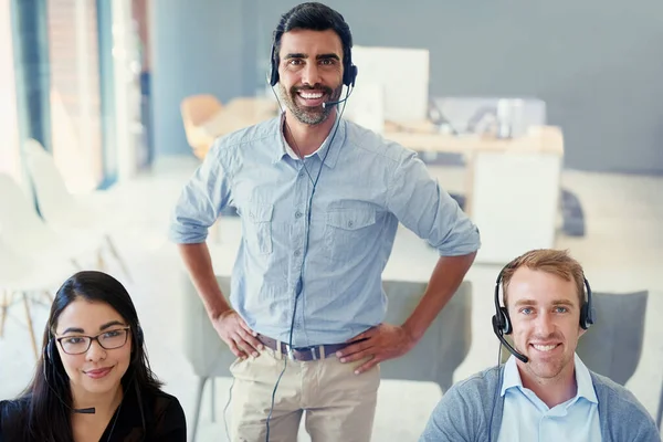 Here to provide you with a first-rate service. Portrait of a team of call centre agents working together in an office