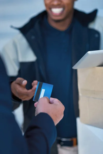 The convenience of credit. a courier accepting a credit card payment from a businessman for a delivery