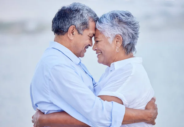 Travel couple giving hug on beach in nature, man and woman with smile on ocean holiday vacation in retirement and happy senior people with smile by sea in summer. Husband and wife in happiness.