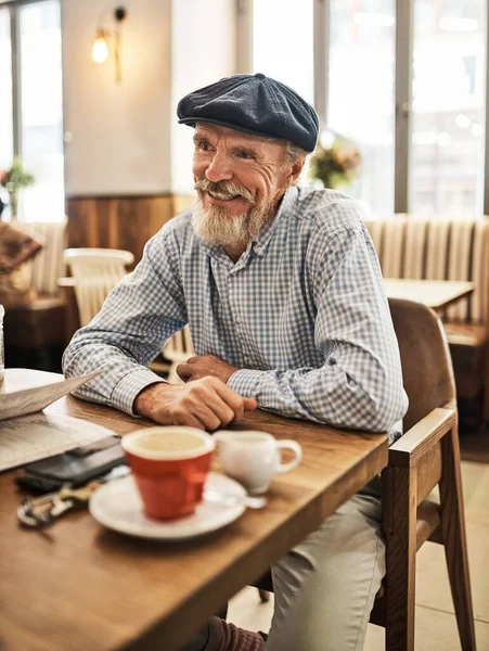 Good coffee, good mood. a happy senior man enjoying a cup of coffee at his favorite cafe