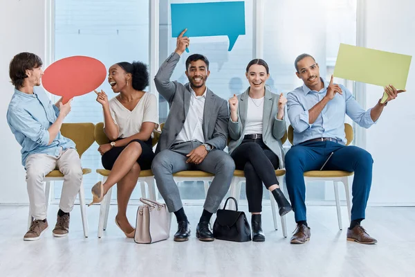 Speech bubbles, voice and vote by business people happy and sitting in an office. A diverse team of employees holding empty comment signs or icons for social media company communication.