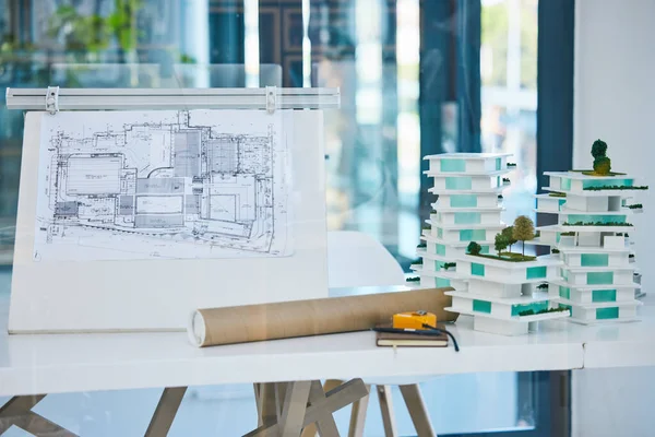 Architecture, blueprints and model building design in empty architectural company office. Vision engineering, real estate or residential planning with 3D structure for luxury apartment infrastructure.