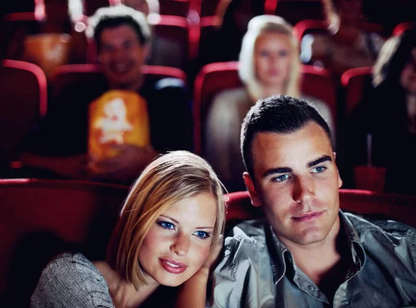 Love couple at cinema or movie theatre to watch entertainment film together at movie theater on a romantic date. Young happy people smile, romance and relationship at movies cinematography theater.