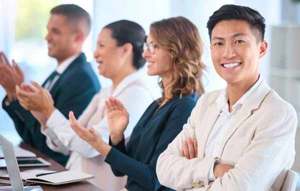 Teamwork, motivation and celebration with clapping business people cheering during speech or presentation. Portrait of a happy employee enjoying his career while sitting with diverse team in training.