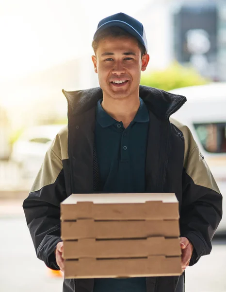 Well get your meal to you, still fresh and hot. Portrait of a young man making a pizza delivery