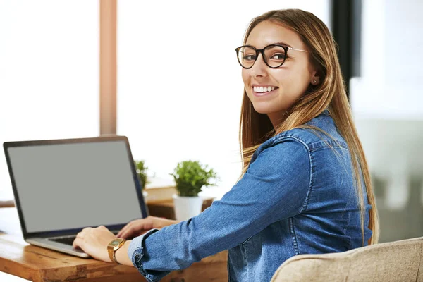 This work is going to guarantee me an A. Portrait of a smiling female university student working on a laptop on campus