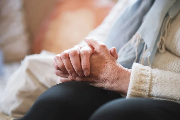 Elderly woman hands clasped retirement concept.
