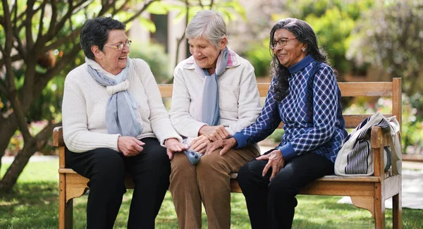 Happy old women sitting on bench in park smiling happy life long friends enjoying retirement together.