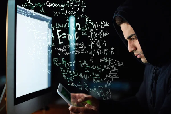 Speaking in a language his computer can understand. a young hacker cracking a computer code in the dark
