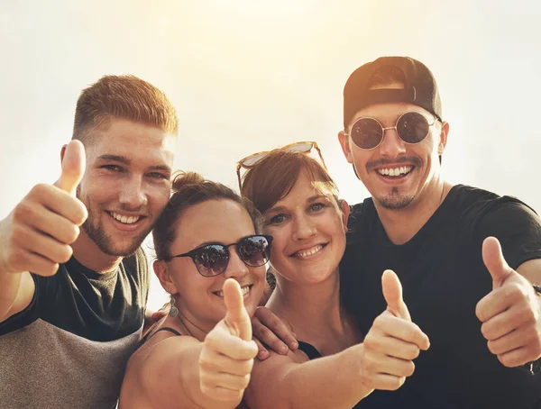 Thumbs up to the weekend. Portrait of a happy group of friends posing together outside