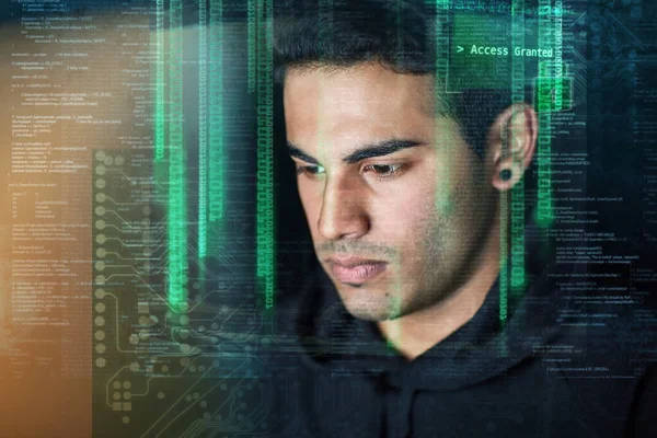 Binary is his second language. a young hacker cracking a computer code in the dark