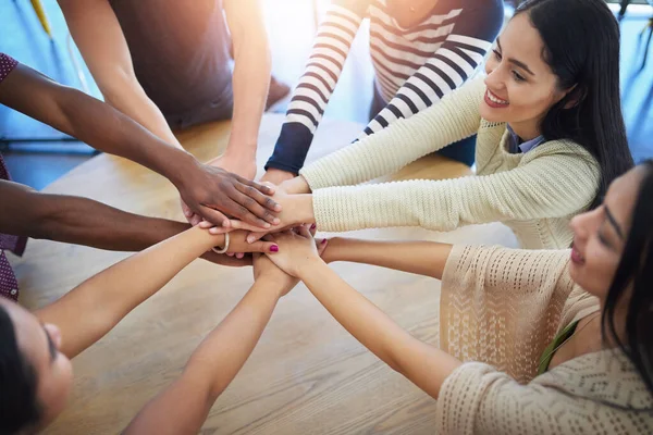 They believe in the power of unity. a group of unidentifiable friends joining their hands in solidarity