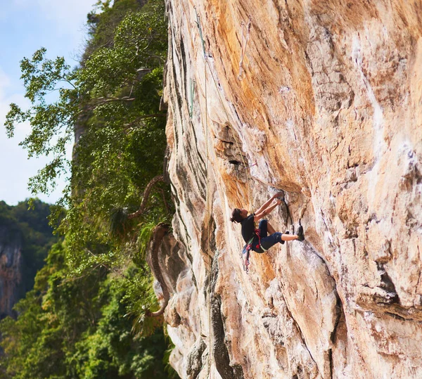 Aim for greater heights. a young rock climber scaling a cliff face