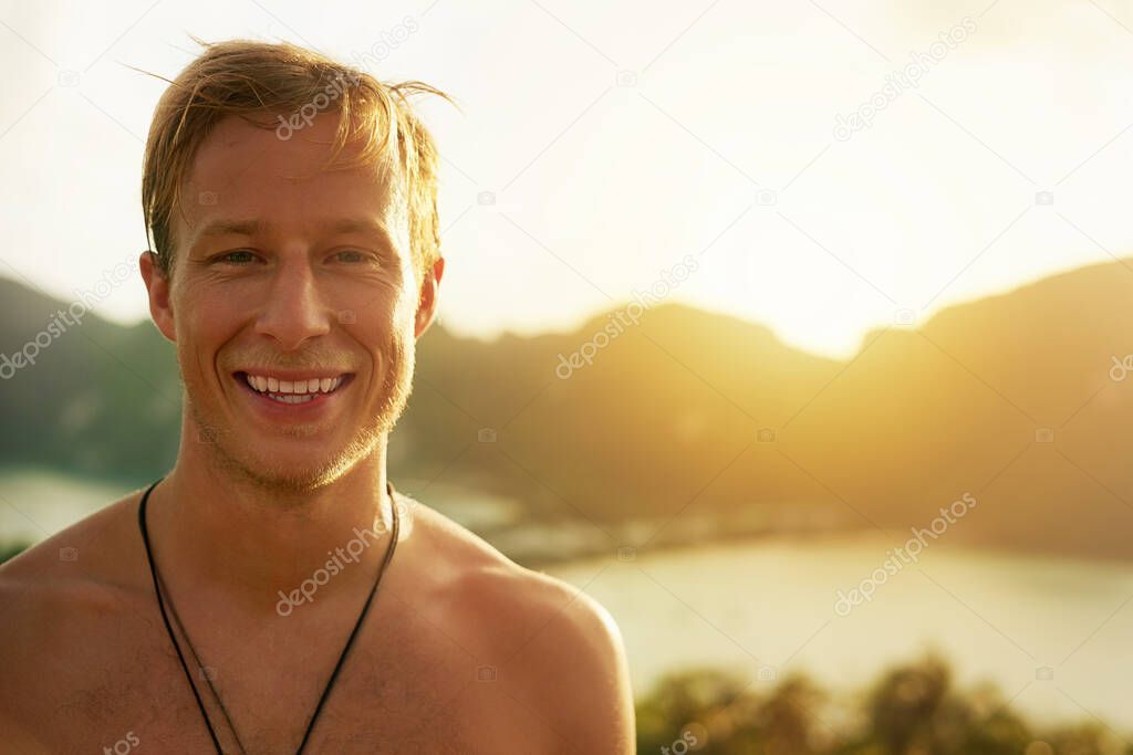 Loving the island life. Portrait of a happy young man admiring a tropical view while on holiday