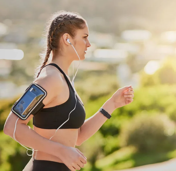 Music is all the motivation she needs. an attractive young woman listening to music while out for her morning run