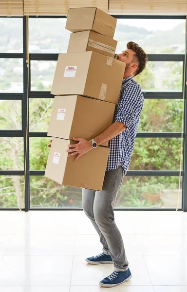 Steady now...a young man carrying a pile of boxes while moving house