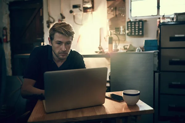 Working the night away. a handsome young man working late in his office