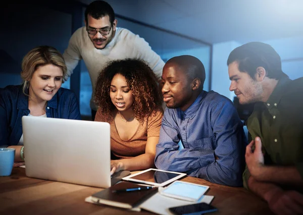 Troubleshooting their new website. a team of young businesspeople working late in the office