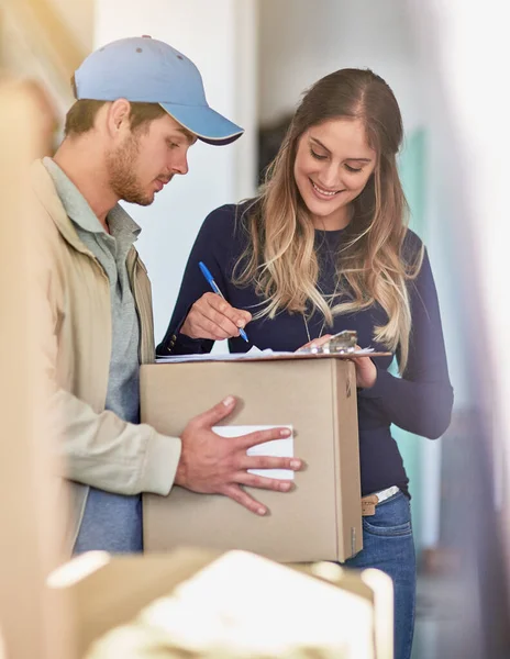 Signed, sealed and delivered. a delivery man making a delivery to a happy customer at her home