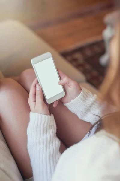 Getting her weekend plans together. High angle shot of a woman texting on her cellphone at home