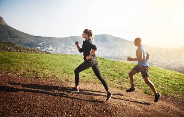 Run to beat yourself, while beating others. a sporty couple out running on a mountain road