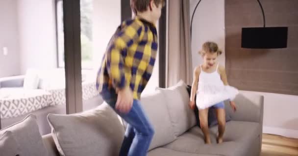 Excited Children Energy Jumping Sofa Together Playing Couch Holiday Home — Vídeo de stock