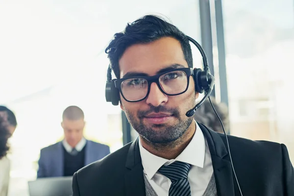 I await your call. Portrait of a friendly support agent working in an office