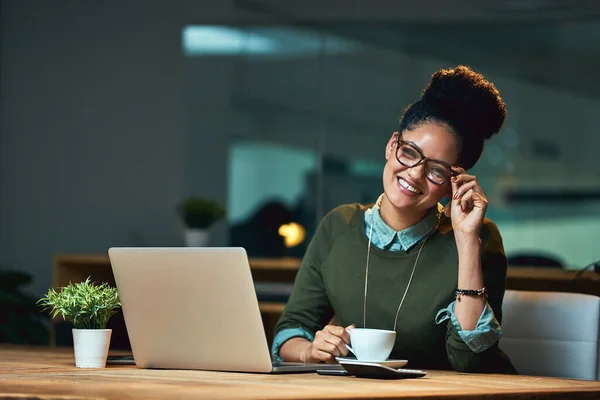 Enjoying the quiet that overtime brings. Portrait of an attractive young woman working on her laptop in the office