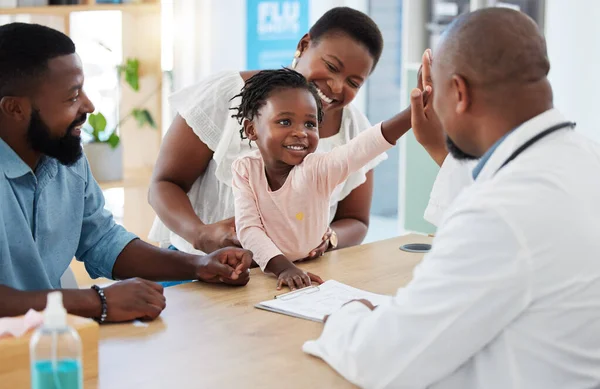 High five, doctor and family with a girl and her parents at the hospital for consulting, appointment and healthcare. Medicine, trust and support in a medical clinic with a health professional.