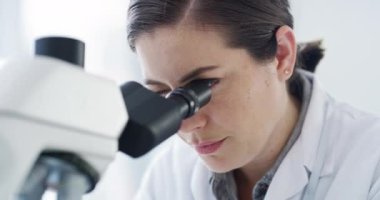 Scientist, microscope and forensic science of a woman working in research lab for a new discovery. Serious female expert in forensics experiment at work looking at particles and samples for results