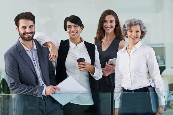 Were all about conquering challenges. Portrait of a group of businesspeople standing together in a modern office