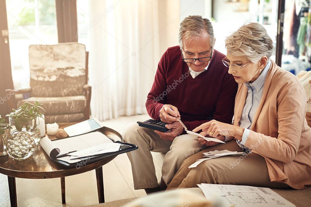 Its necessary to have a contingency plan for old age. an elderly couple working out a budget while sitting on the living room sofa