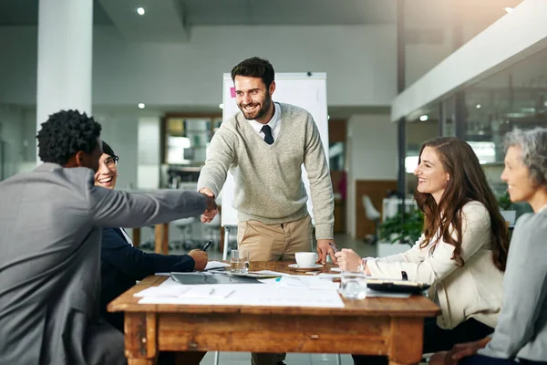 Welcome to the team. two businessmen shaking hands during a meeting