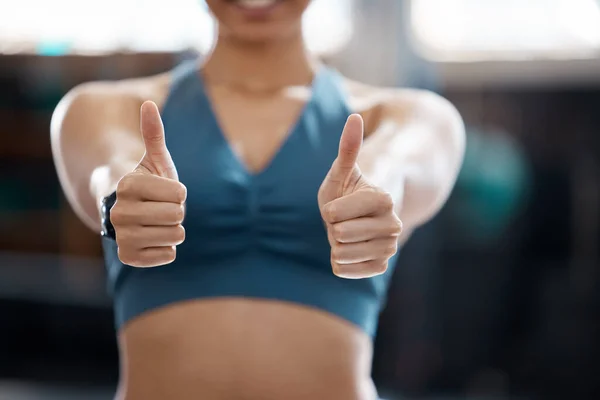 Woman, fitness and thumbs up to health, workout and training to live an active, wellness and healthy lifestyle with gym. Personal trainer, yes and thank you for positive energy in our sports club.